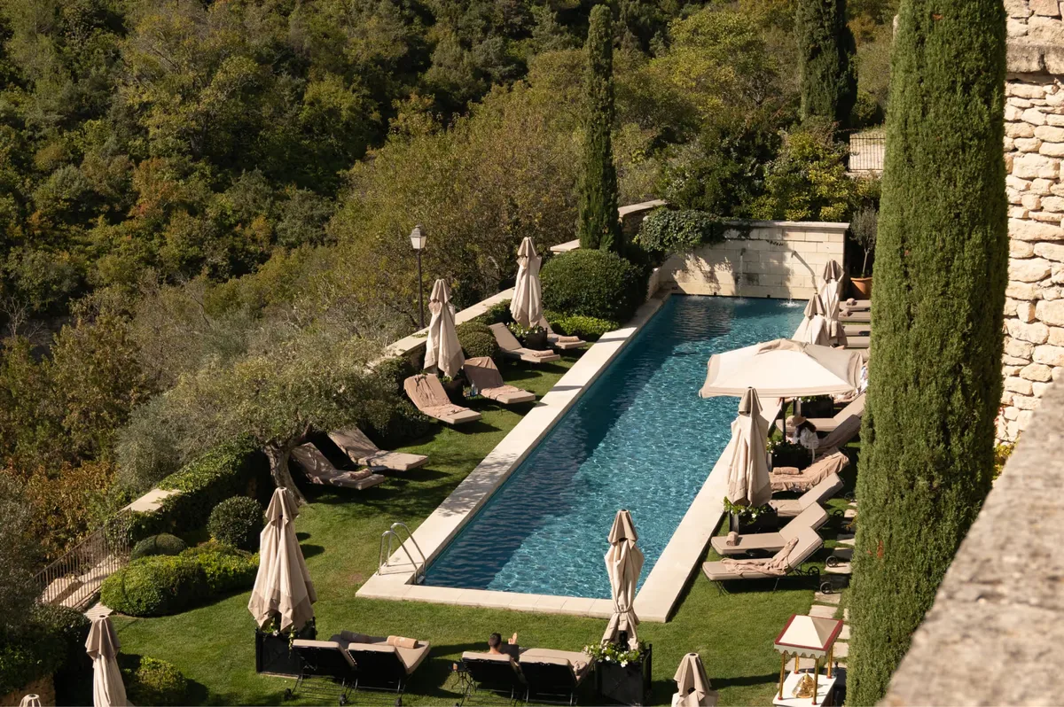Pool with lounge chairs overlooking cypress-lined valley