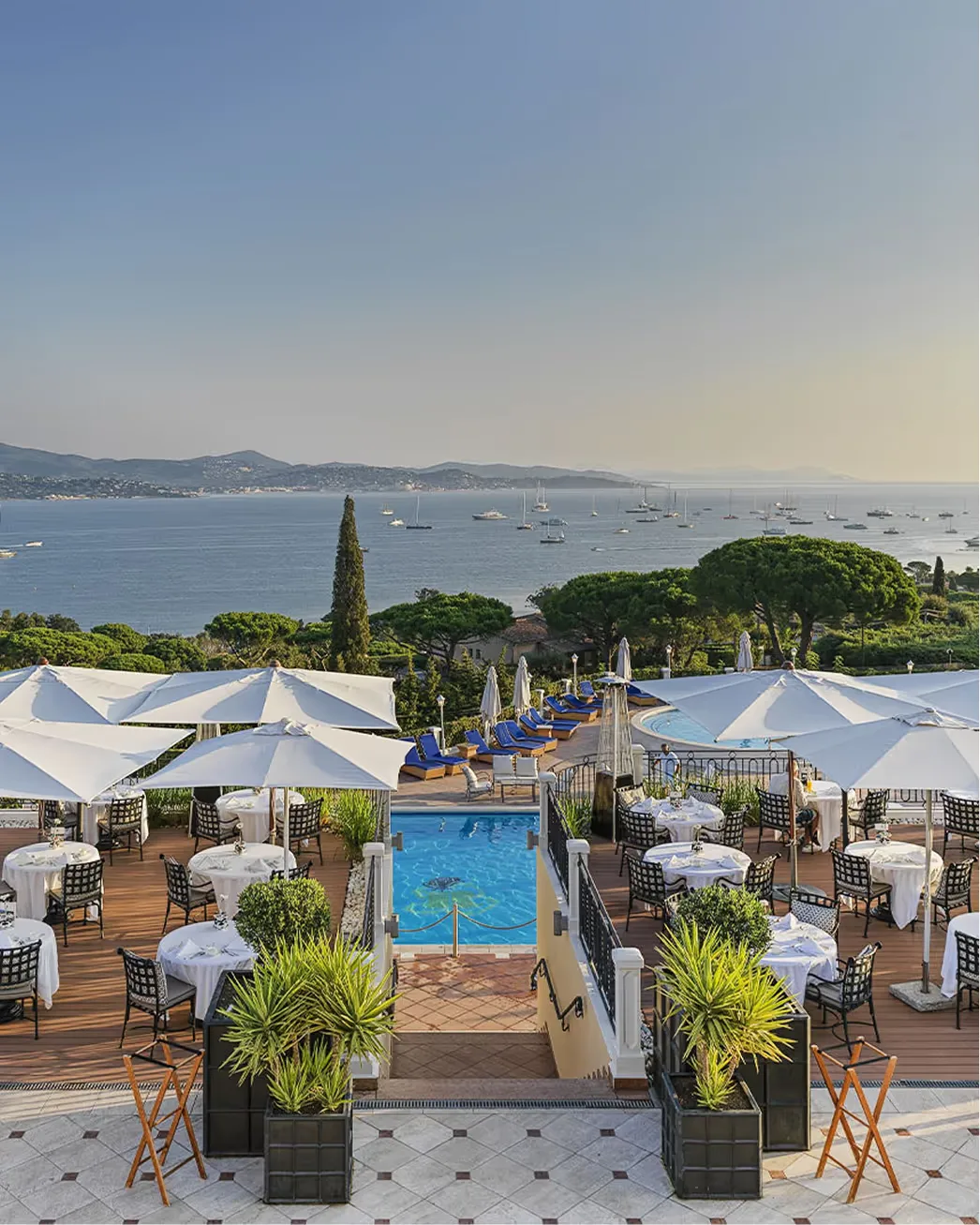 White terraced pools and cream parasols overlooking the Mediterranean coastline