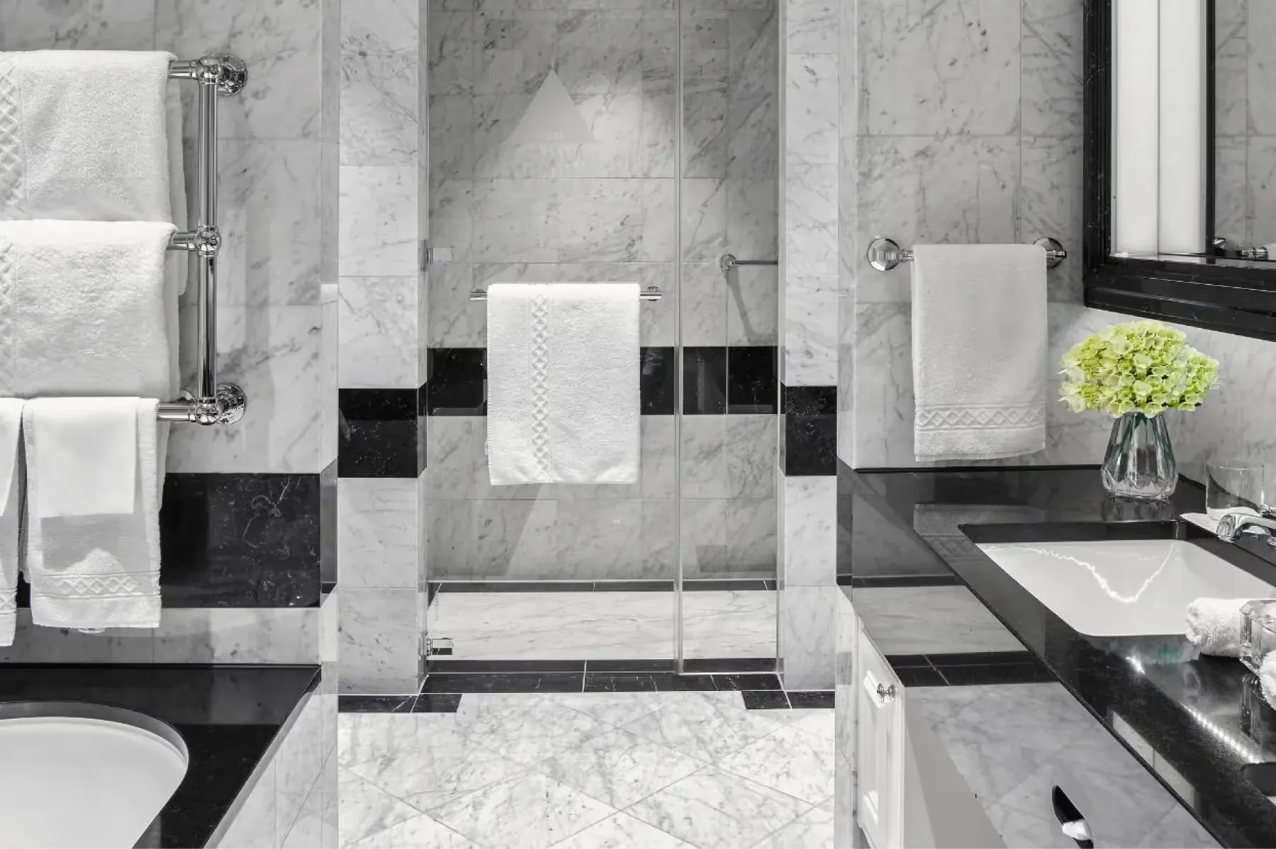 Marble bathroom with black and white geometric tile pattern