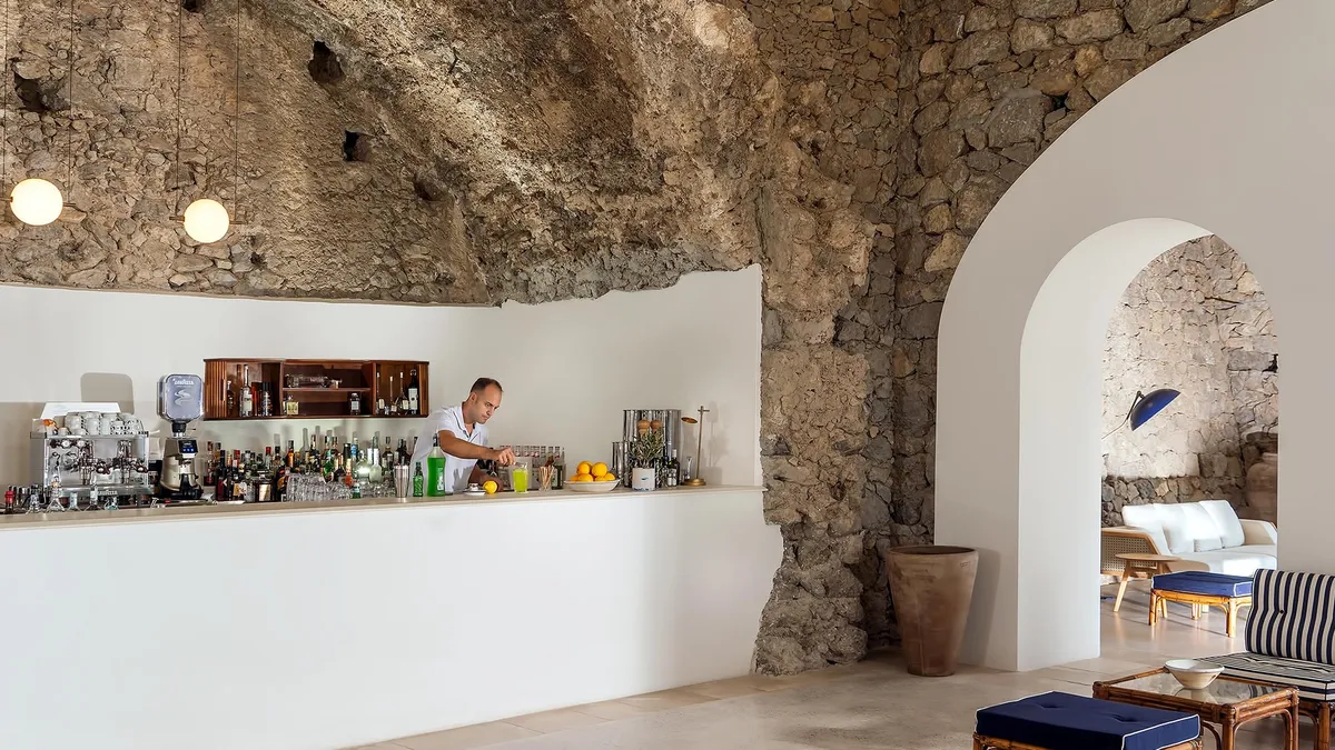 Bar counter in stone-walled space with exposed masonry and display shelving