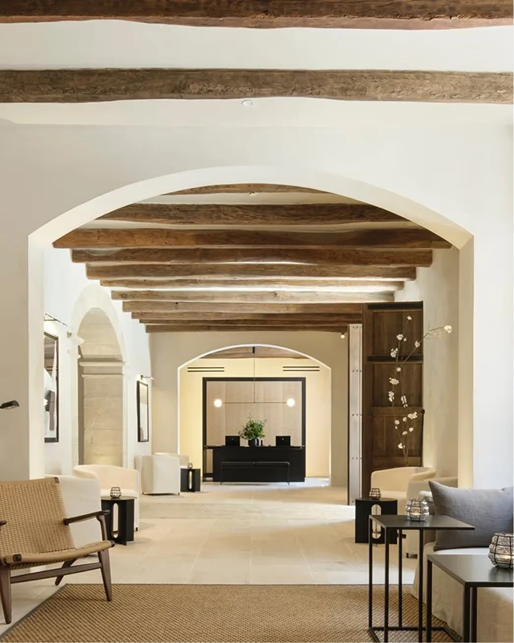 Minimalist archway with exposed wooden ceiling beams and neutral palette