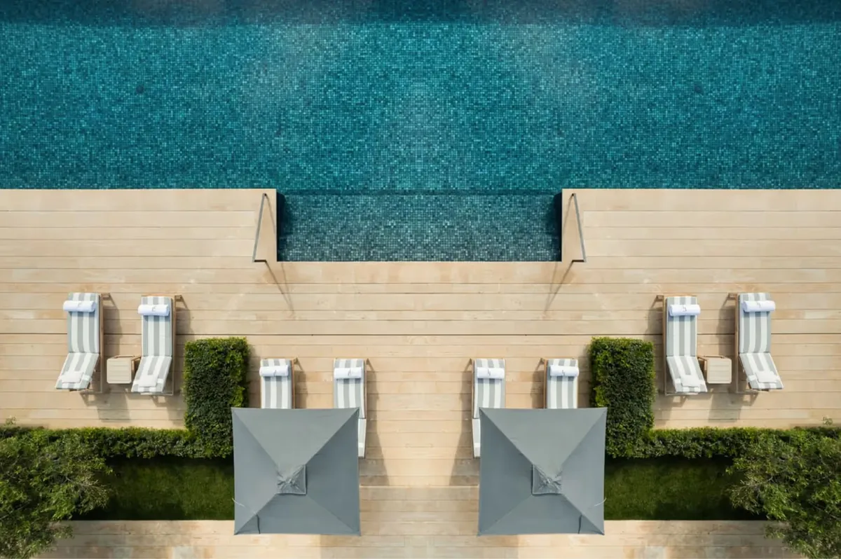 Pool deck with lounge chairs and turquoise water viewed from above
