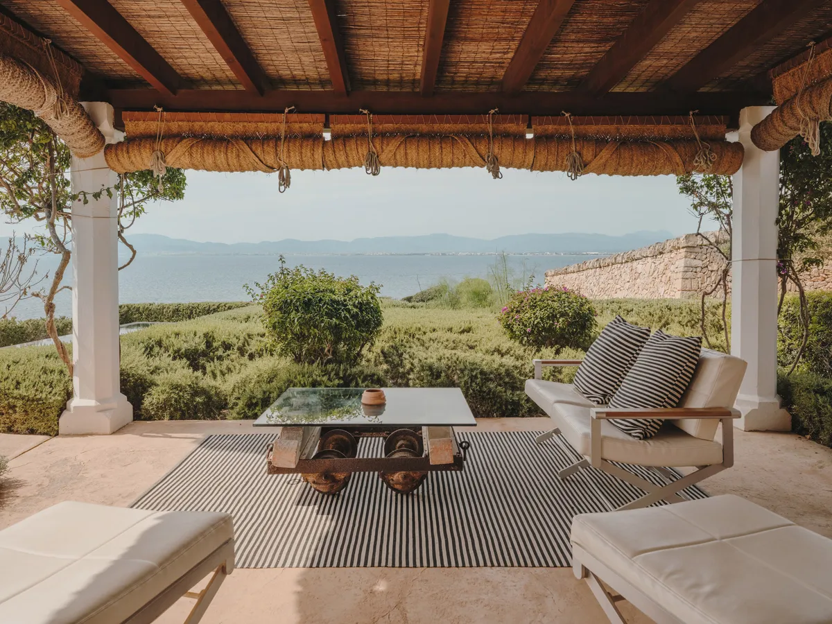 A terracotta villa facade set in golden-hour light, framed by cypress landscaping