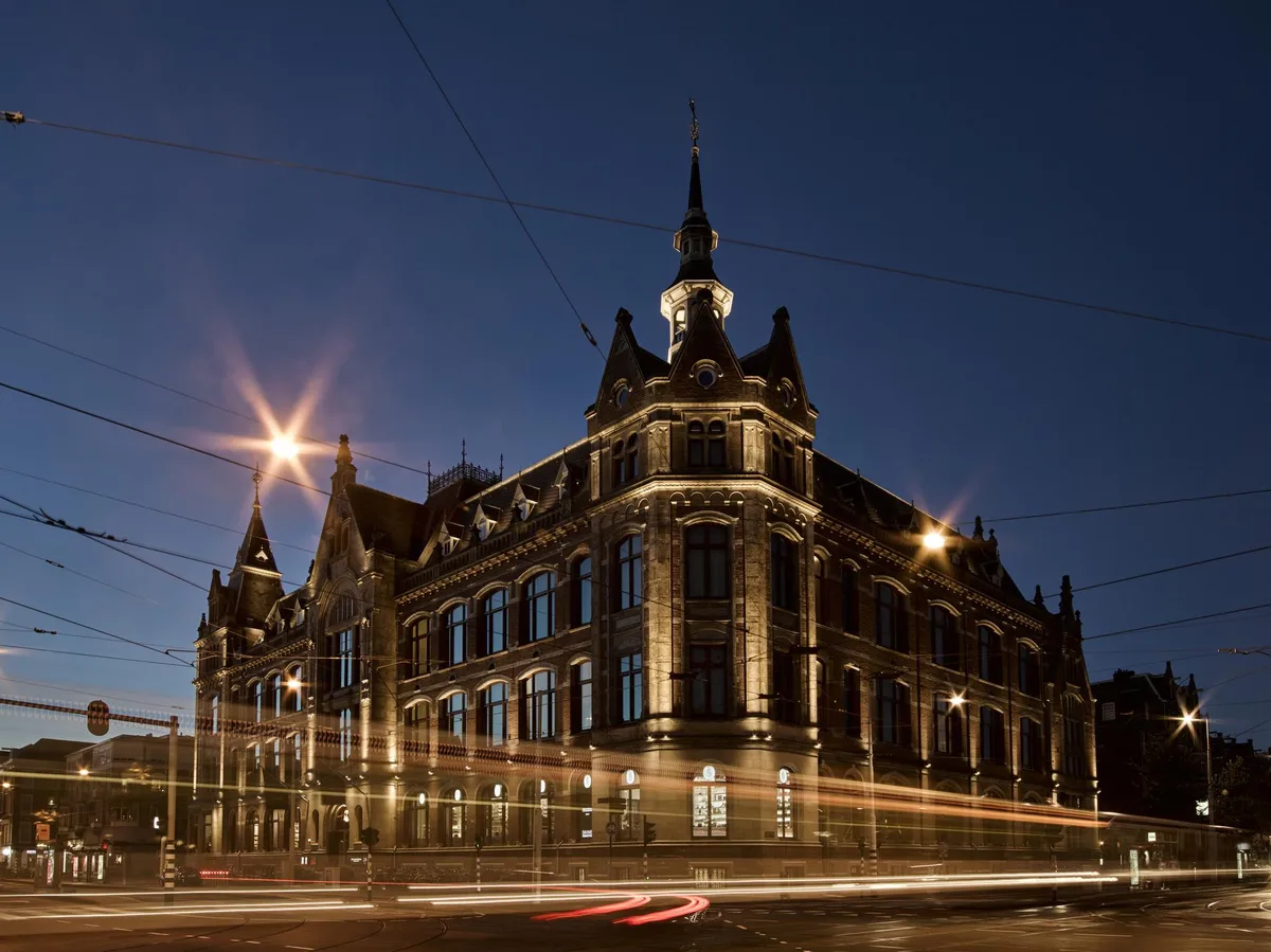 The 19th-century landmark building exterior lit at dusk with its distinctive architecture and turrets