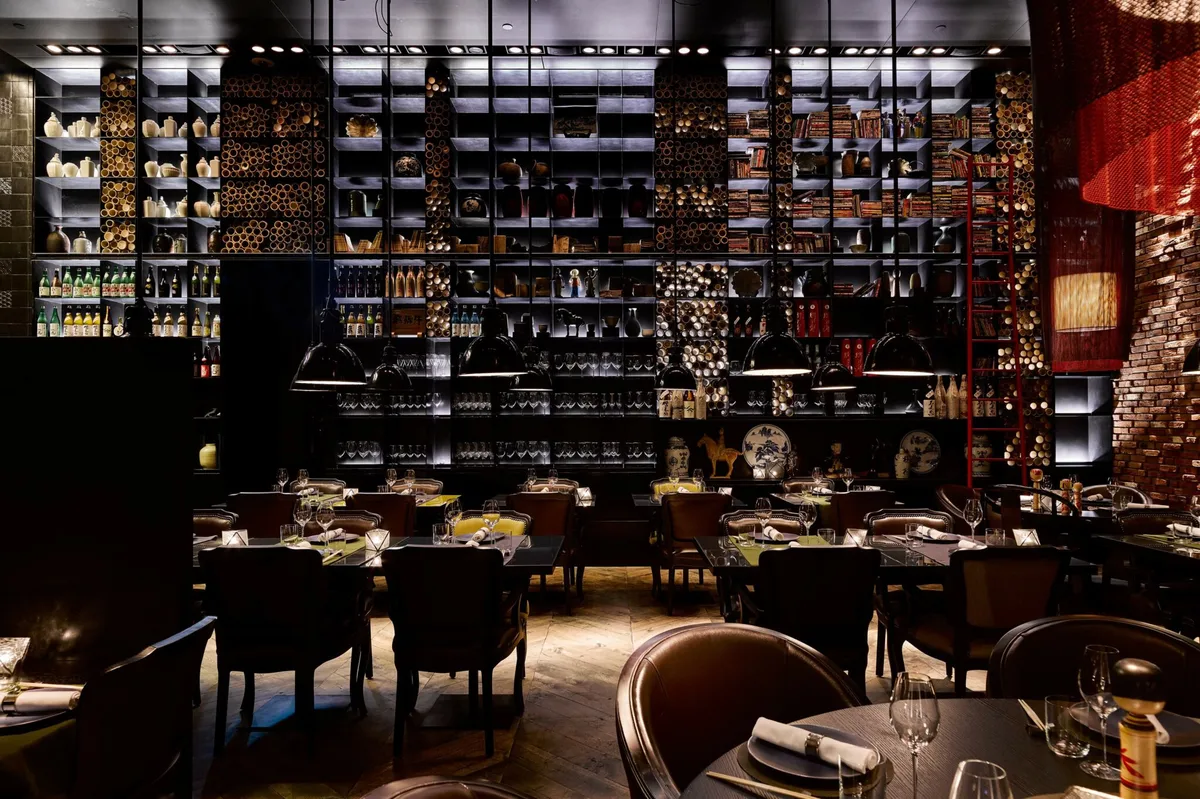 Taiko Bar with dark wood cabinetry displaying spirits, leather seating, and mood lighting