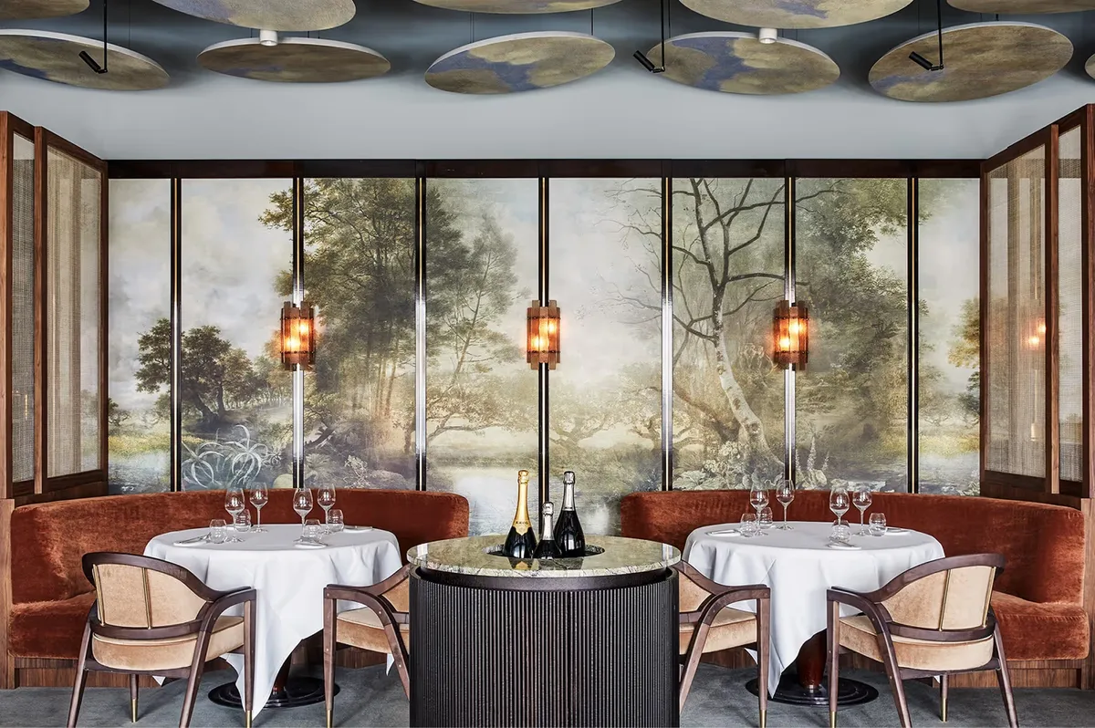 Dining room with glass wine display, terracotta walls, and brass fixtures