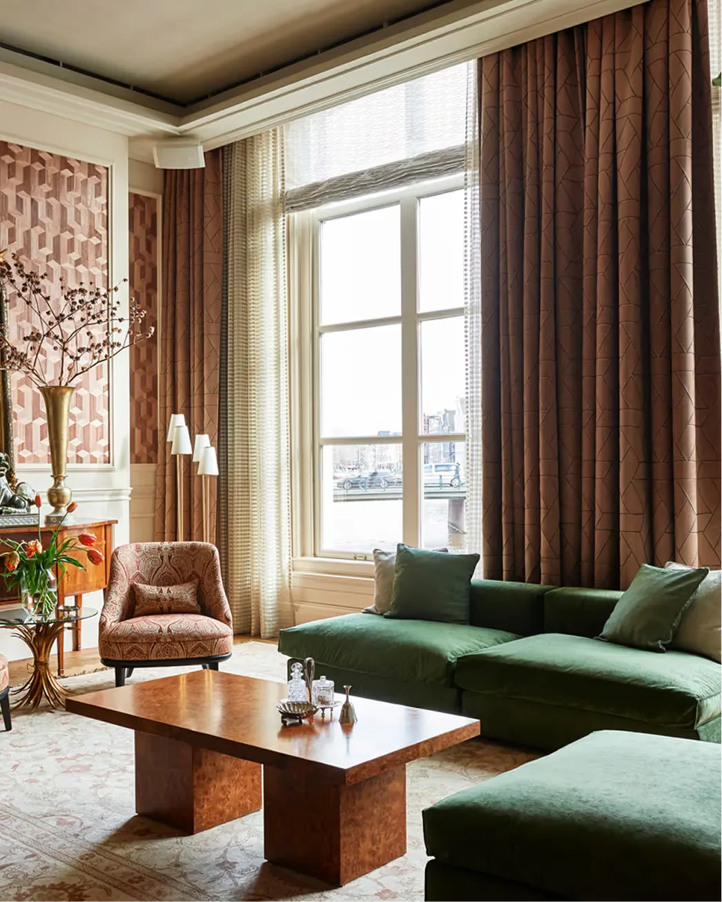 Riverside suite with green sofa, tall windows, and heritage architectural details