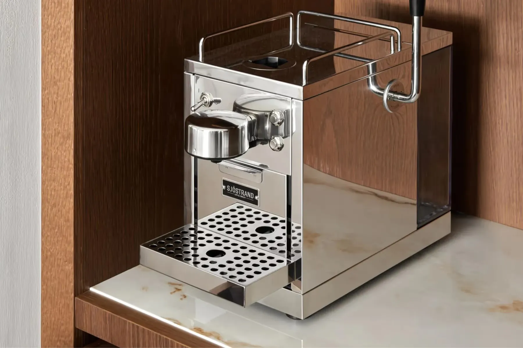 Espresso machine built into wood cabinetry in room amenities station
