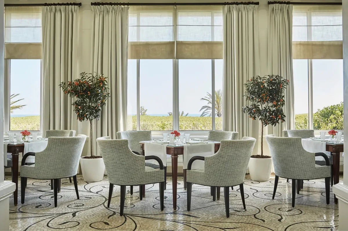 Bright dining area with floor-to-ceiling windows and contemporary furnishings