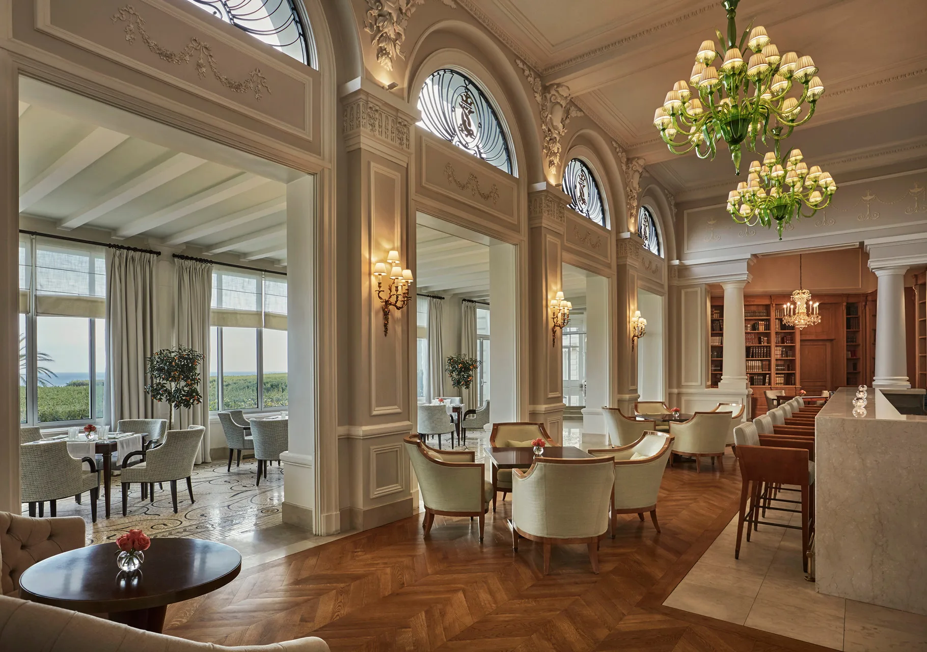 Formal dining room with gilded mirrors, crystal chandelier, and cream moldings
