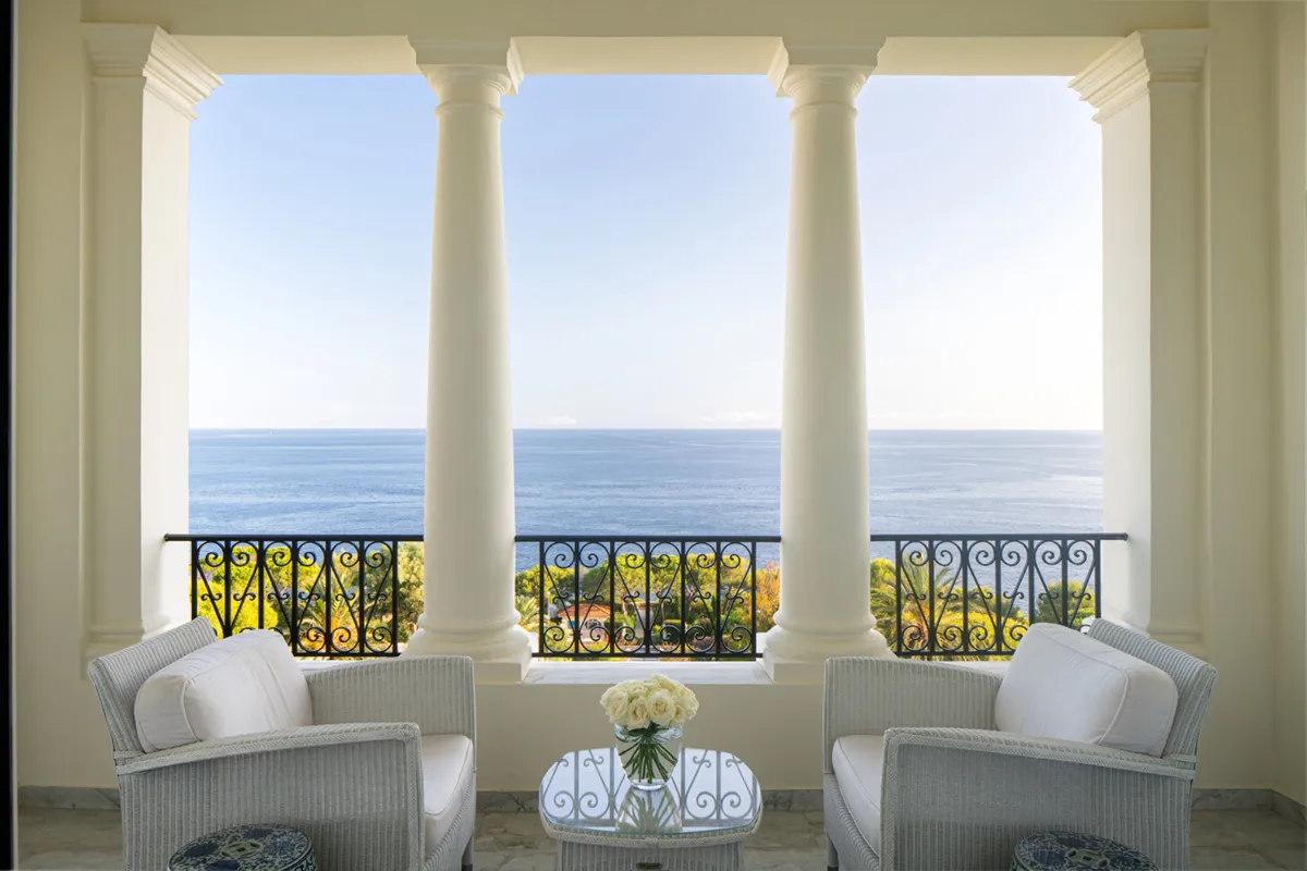 Three arched windows with sea views and armchairs overlooking the Mediterranean