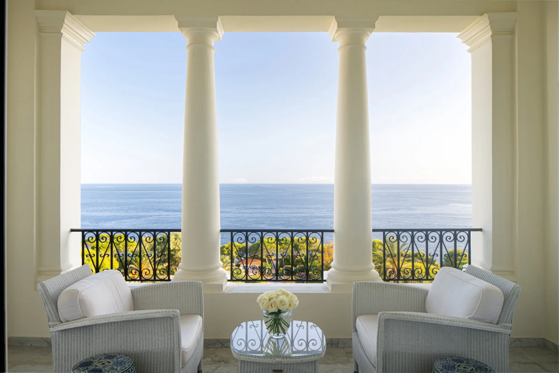 Three arched windows with sea views and armchairs overlooking the Mediterranean