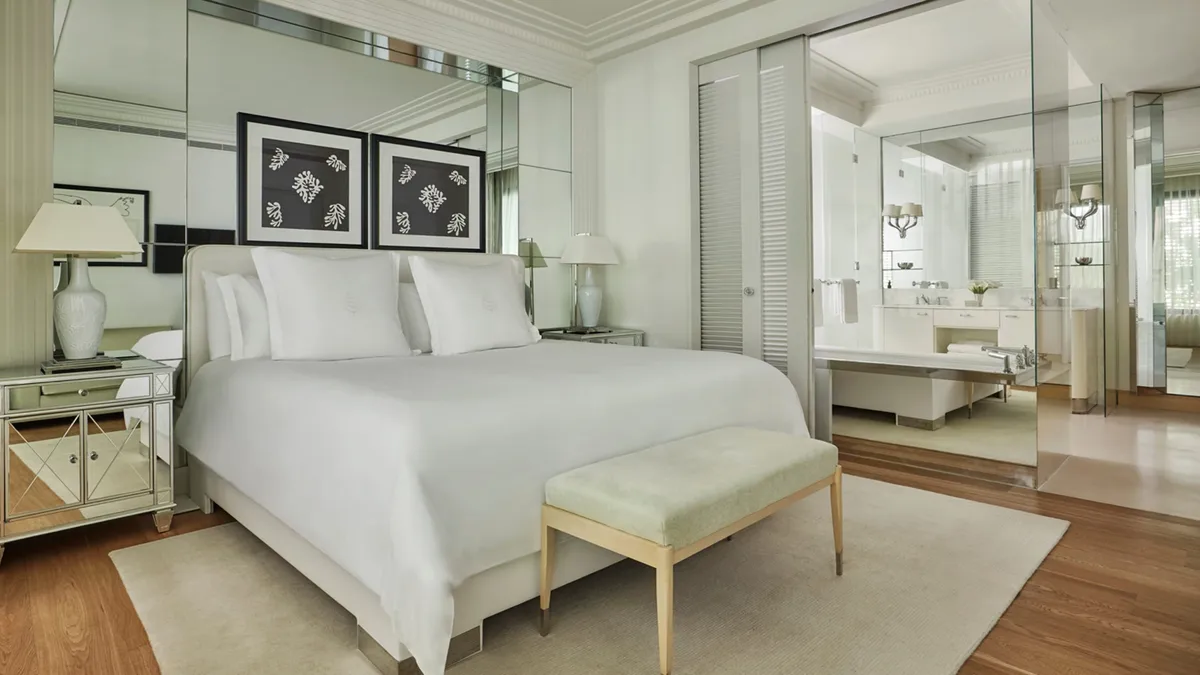 Contemporary bedroom with mirror-lined closet and pale wood furnishings