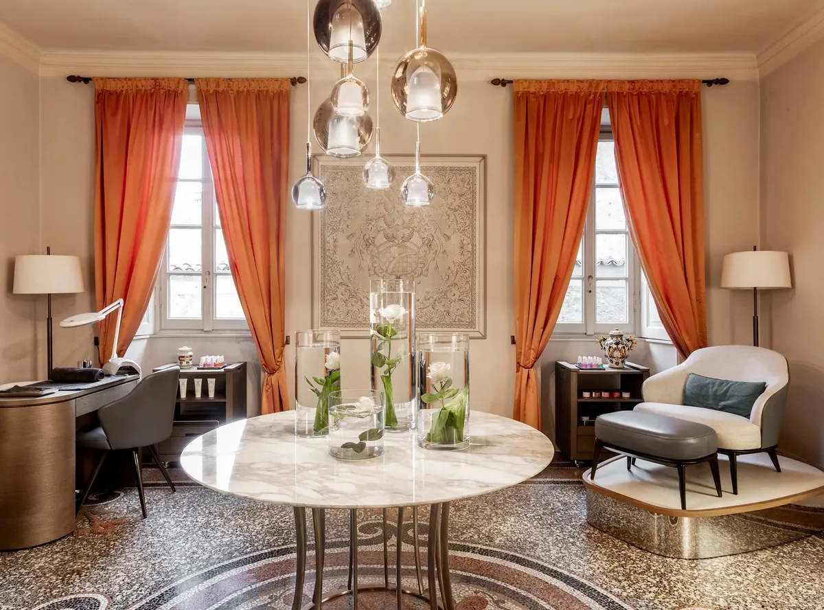 Elegant sitting room with round table, pendant lights, and red curtains