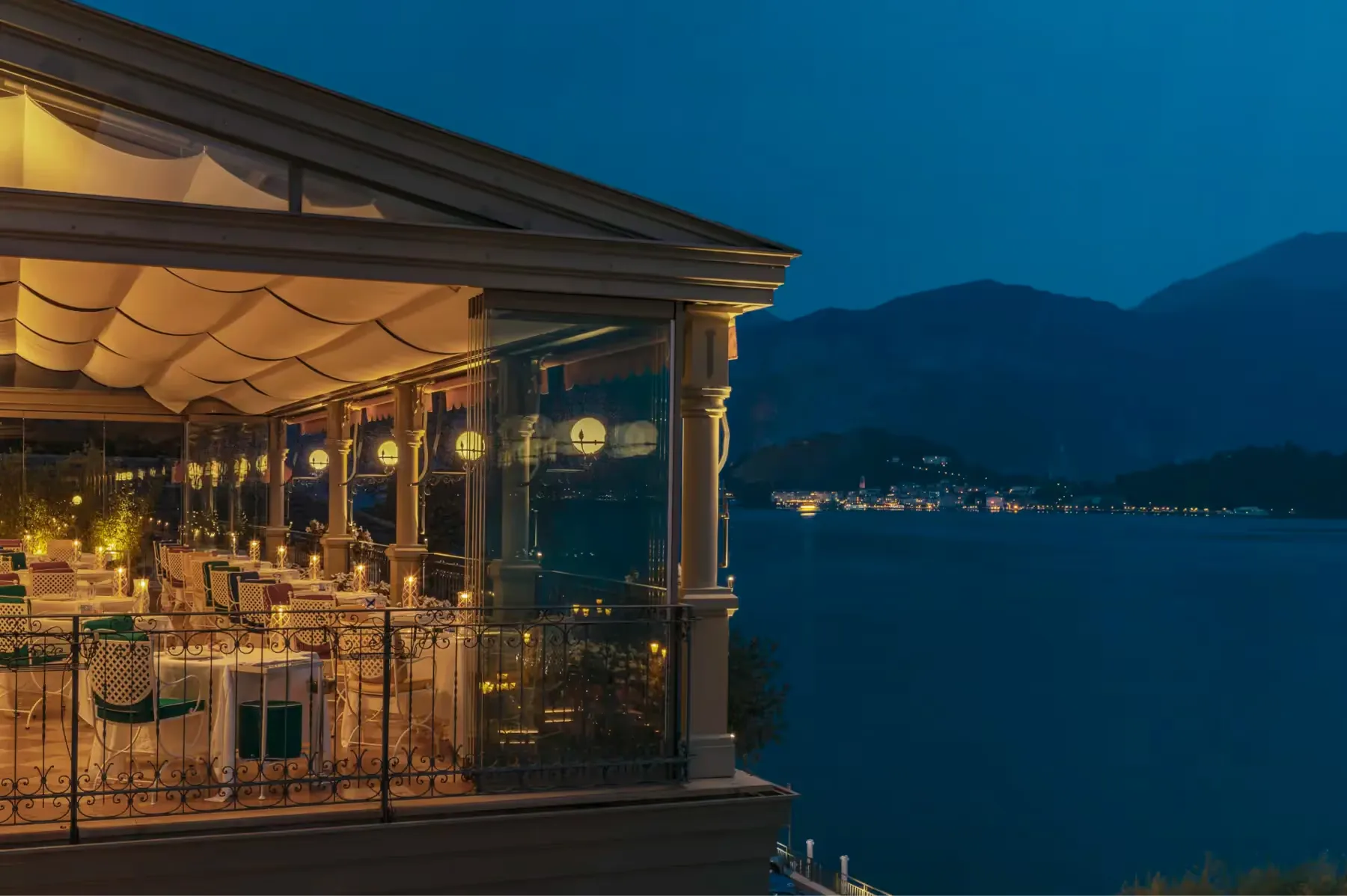 Lit restaurant pavilion reflected on dark water at twilight