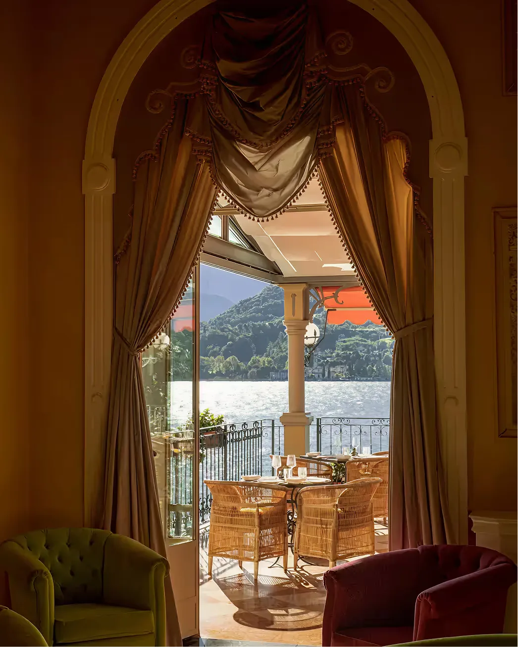 Arched doorway to a suite terrace with draped fabrics and lake view