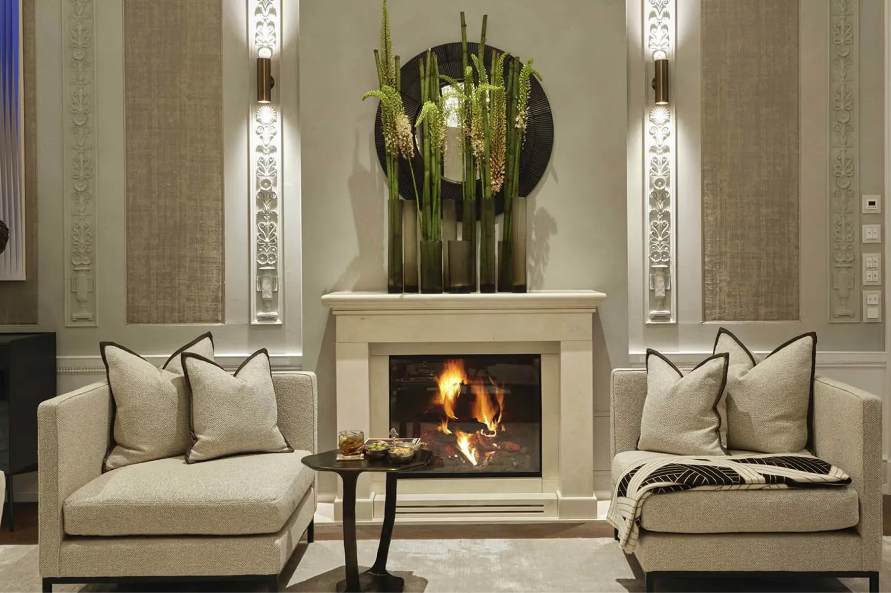 Symmetrical lounge with cream sofas flanking a central fireplace