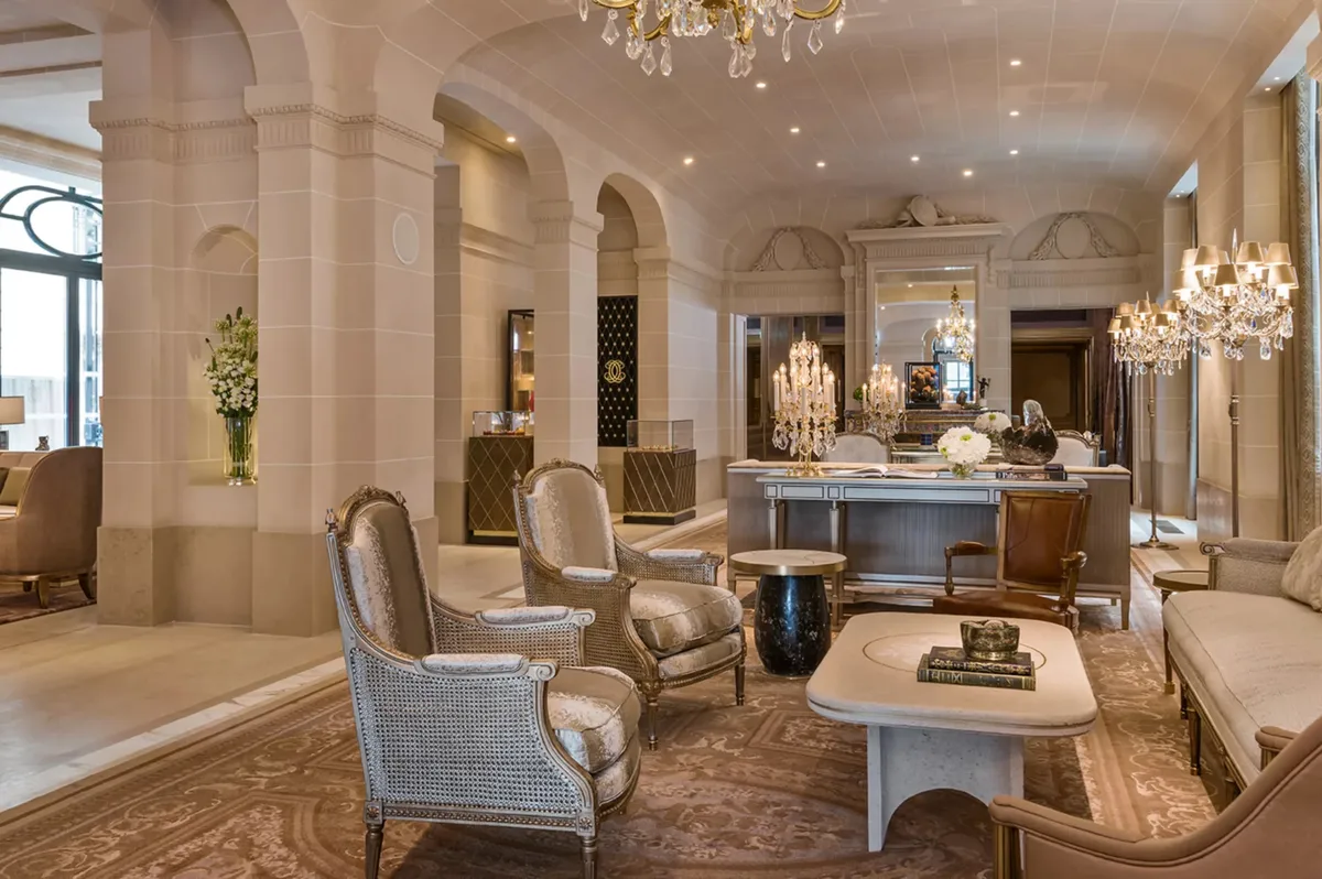 Grand lobby with chandelier, pale columns, and spacious classical architecture