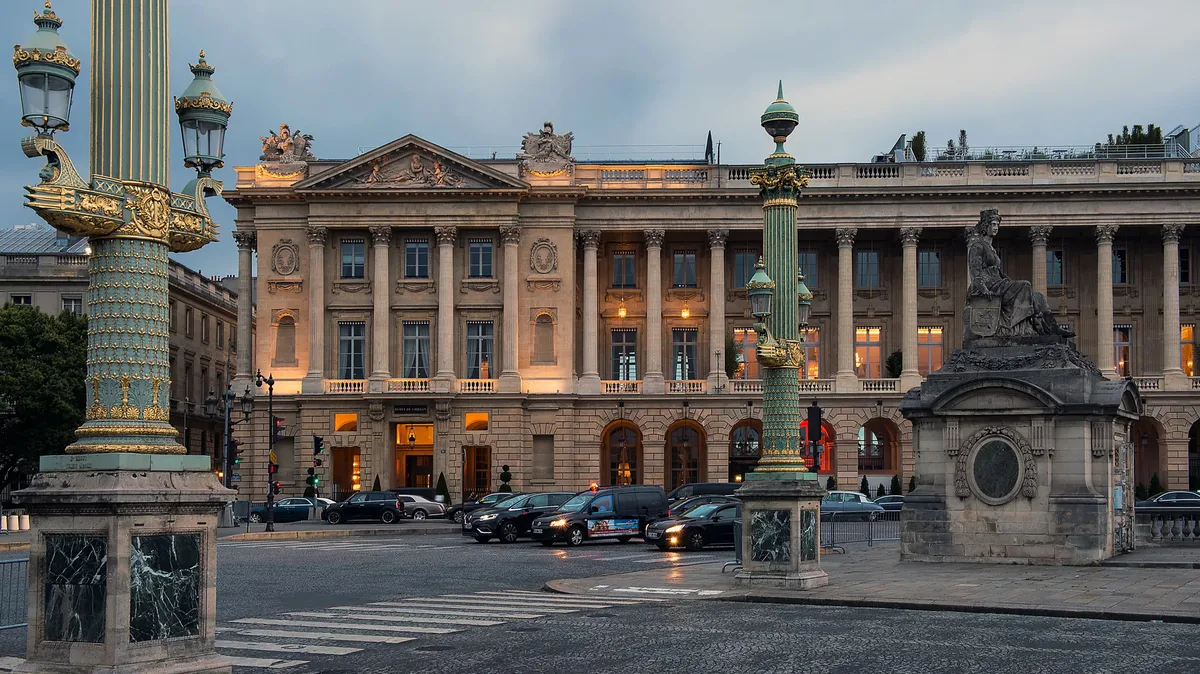 Building facade illuminated at dusk on Paris street corner with classical proportions