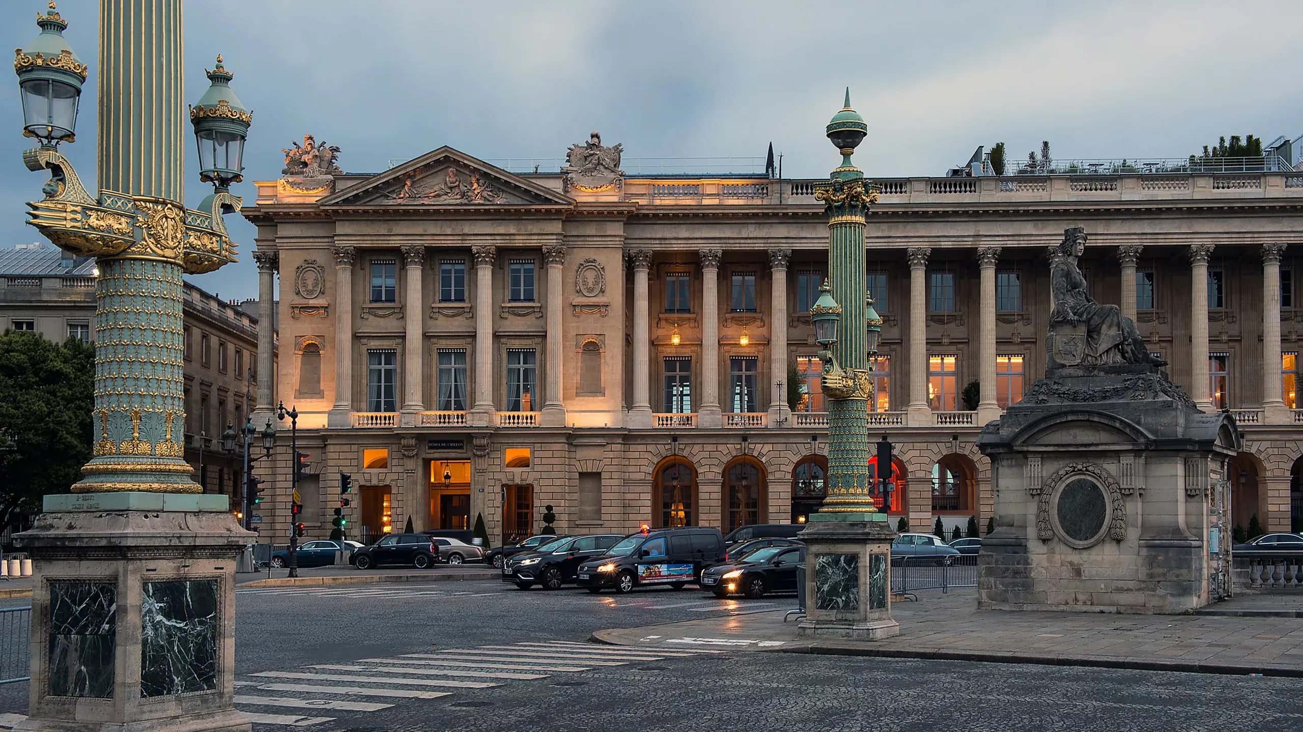 Building facade illuminated at dusk on Paris street corner with classical proportions