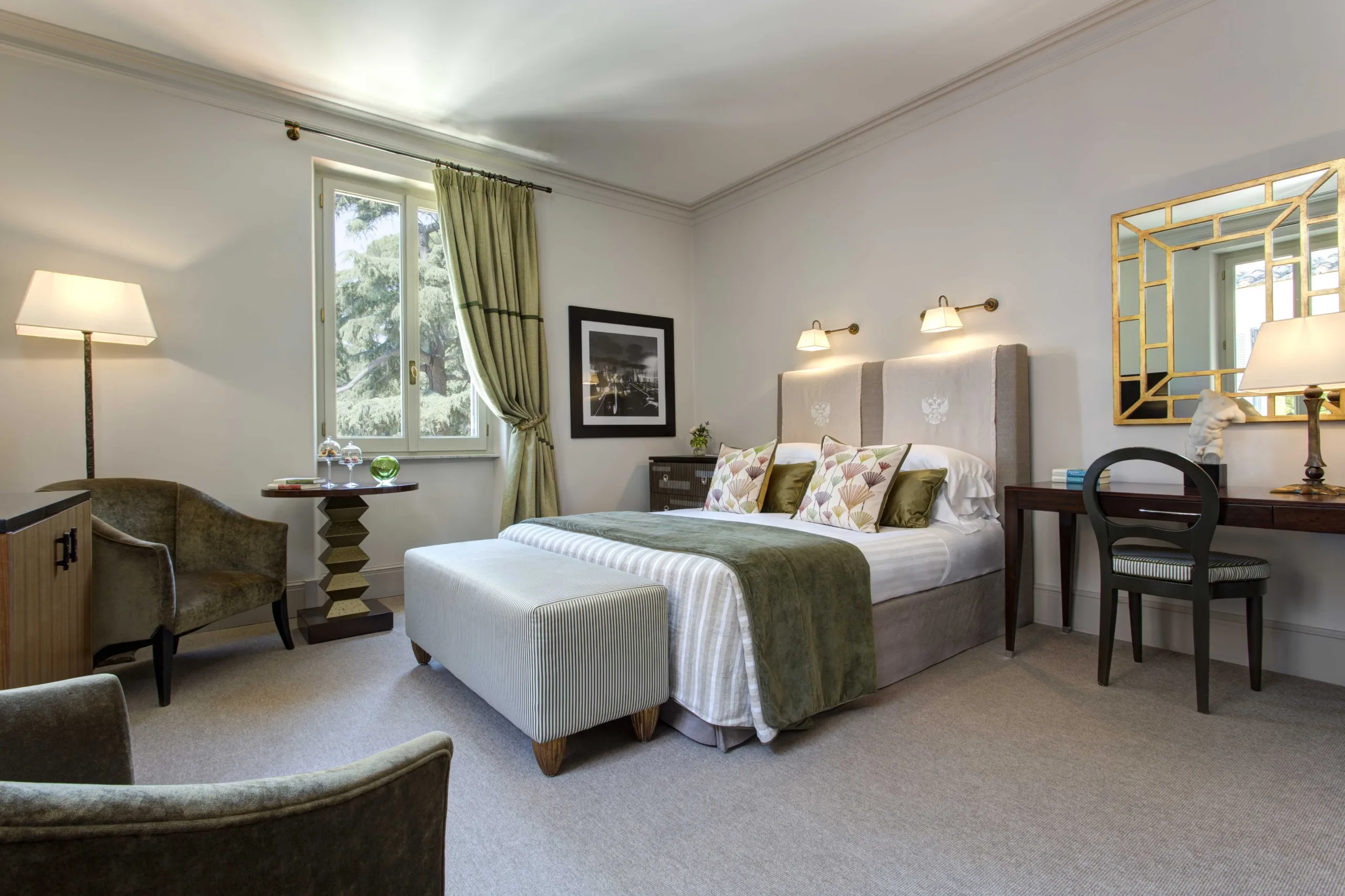 Bedroom with white bedding, green accents, and furnishings with garden windows