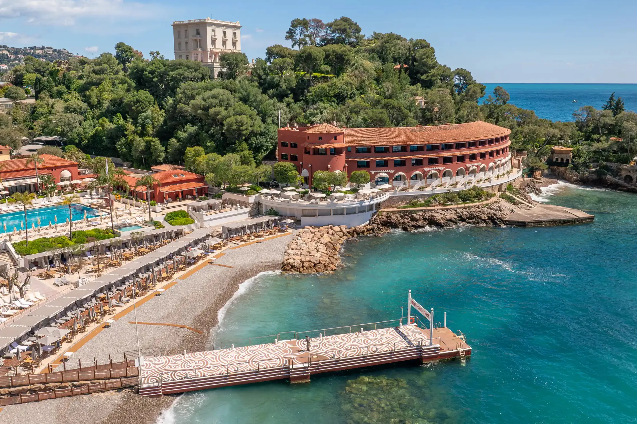 Coastal resort and spa facilities with red-roofed buildings and boat pier