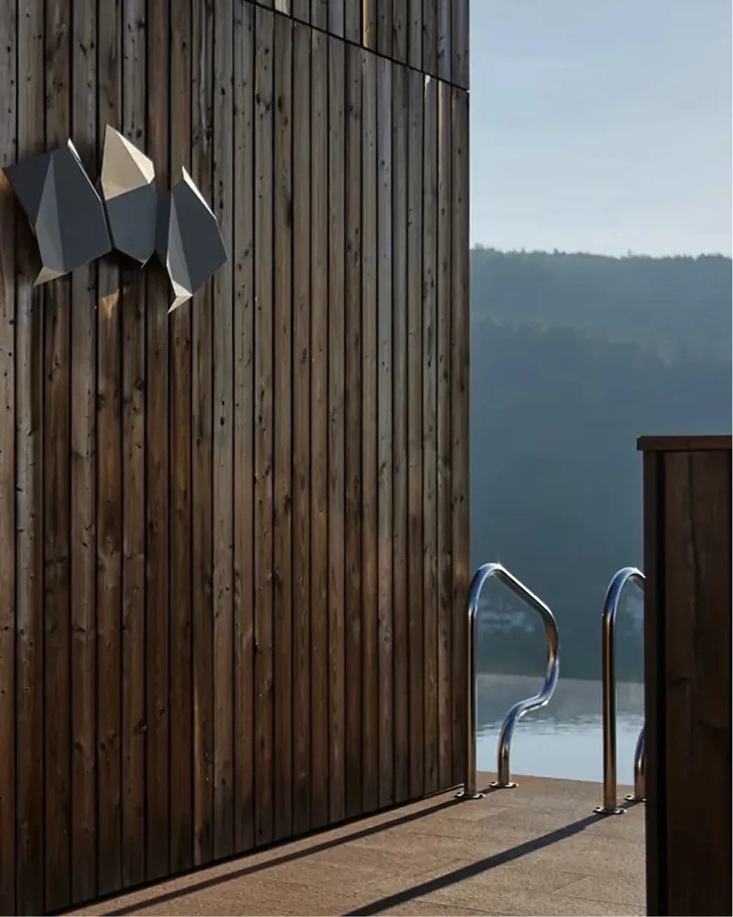 Wooden slatted wall with glass doors opening onto a terrace overlooking mountains