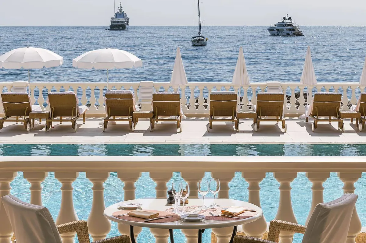 Upper terrace with sea views, umbrella canopies, and dining table
