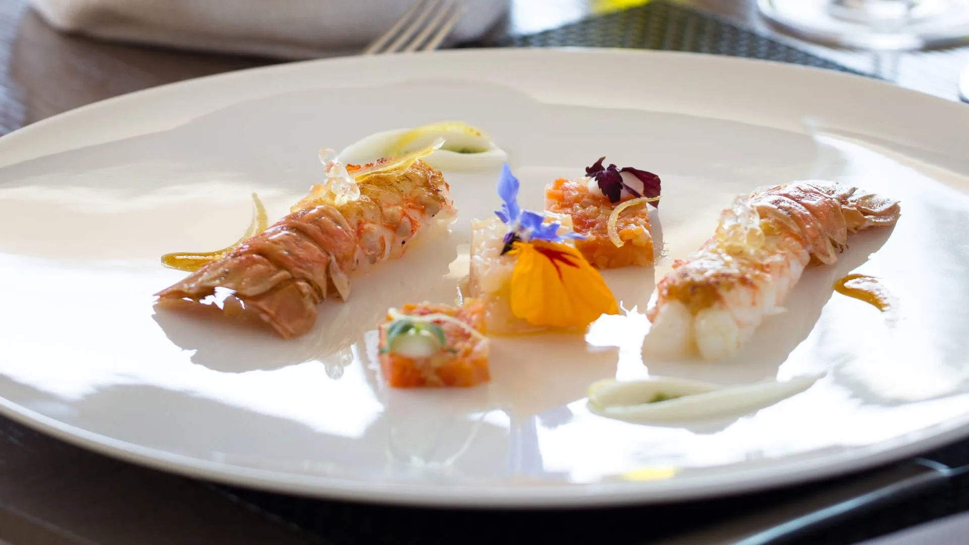 Artistic plated dish with pale protein and colorful garnishes