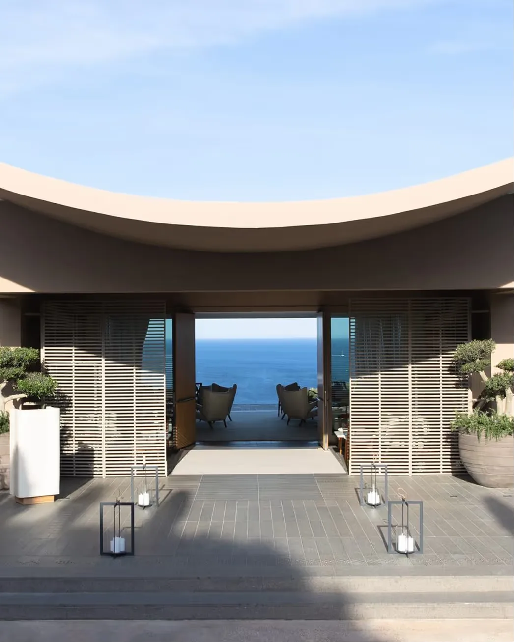 Coastal terrace with white lounges framing the Mediterranean Sea