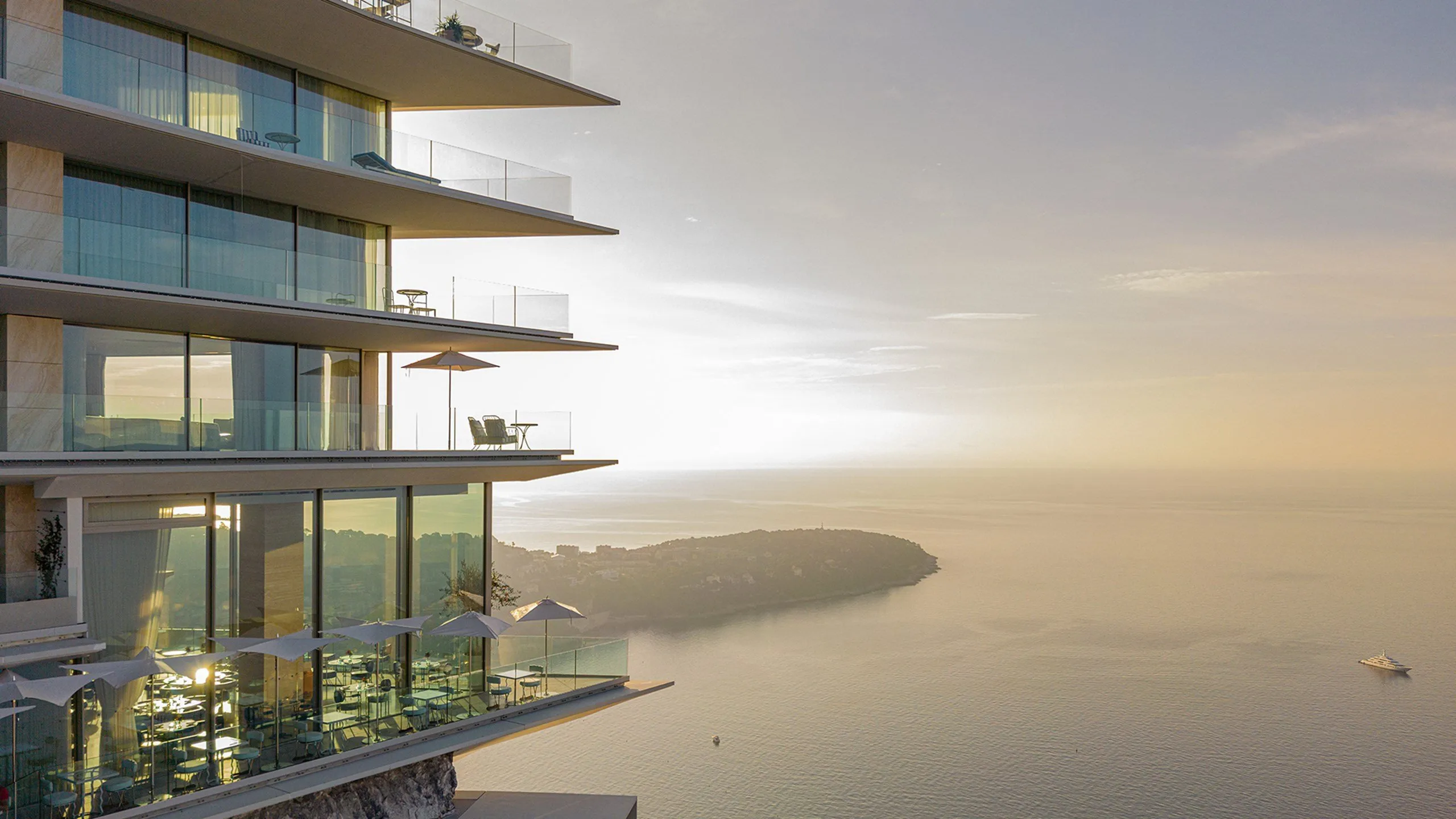 Glass-fronted suites overlooking Mediterranean at sunset