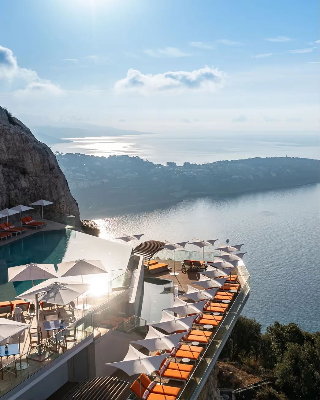 Hotel facade with orange sun lounges overlooking Mediterranean Sea
