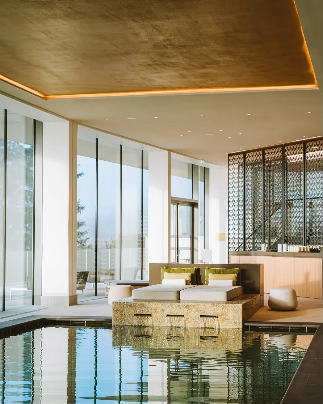 Modern suite with seating area, gold-accented ceiling, and large windows with vineyard valley views