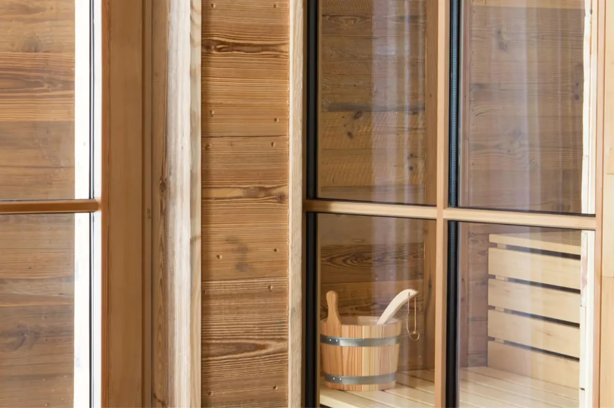 Wooden sauna interior with glass sliding doors