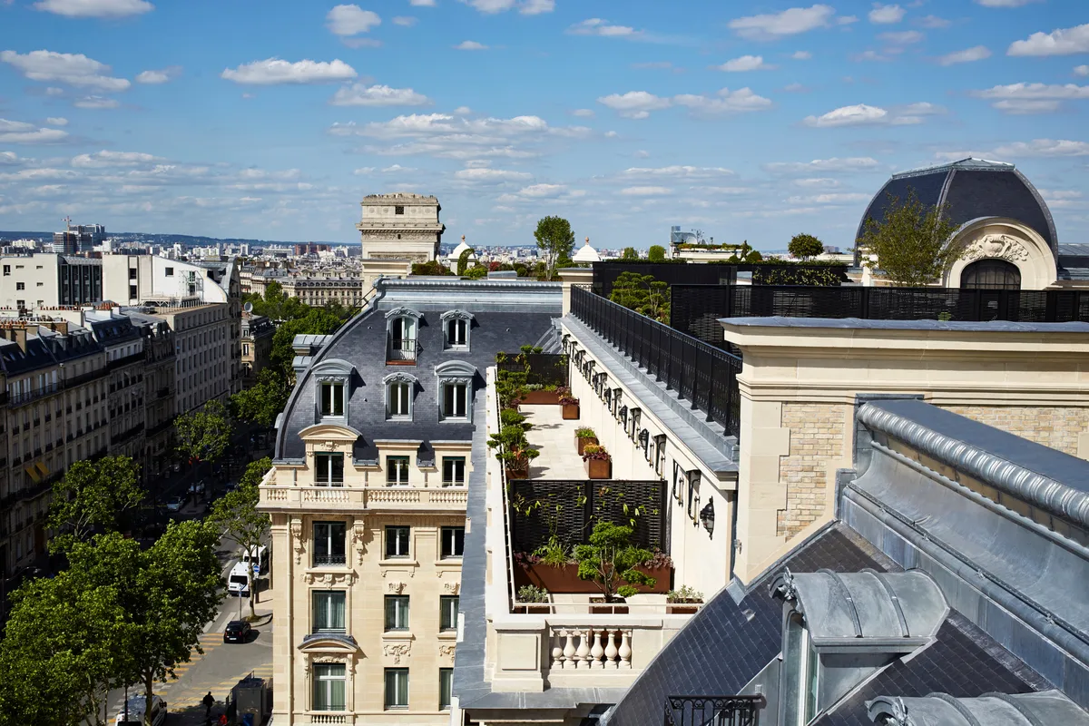 Aerial view of Parisian roofscape with historic buildings and clear sky
