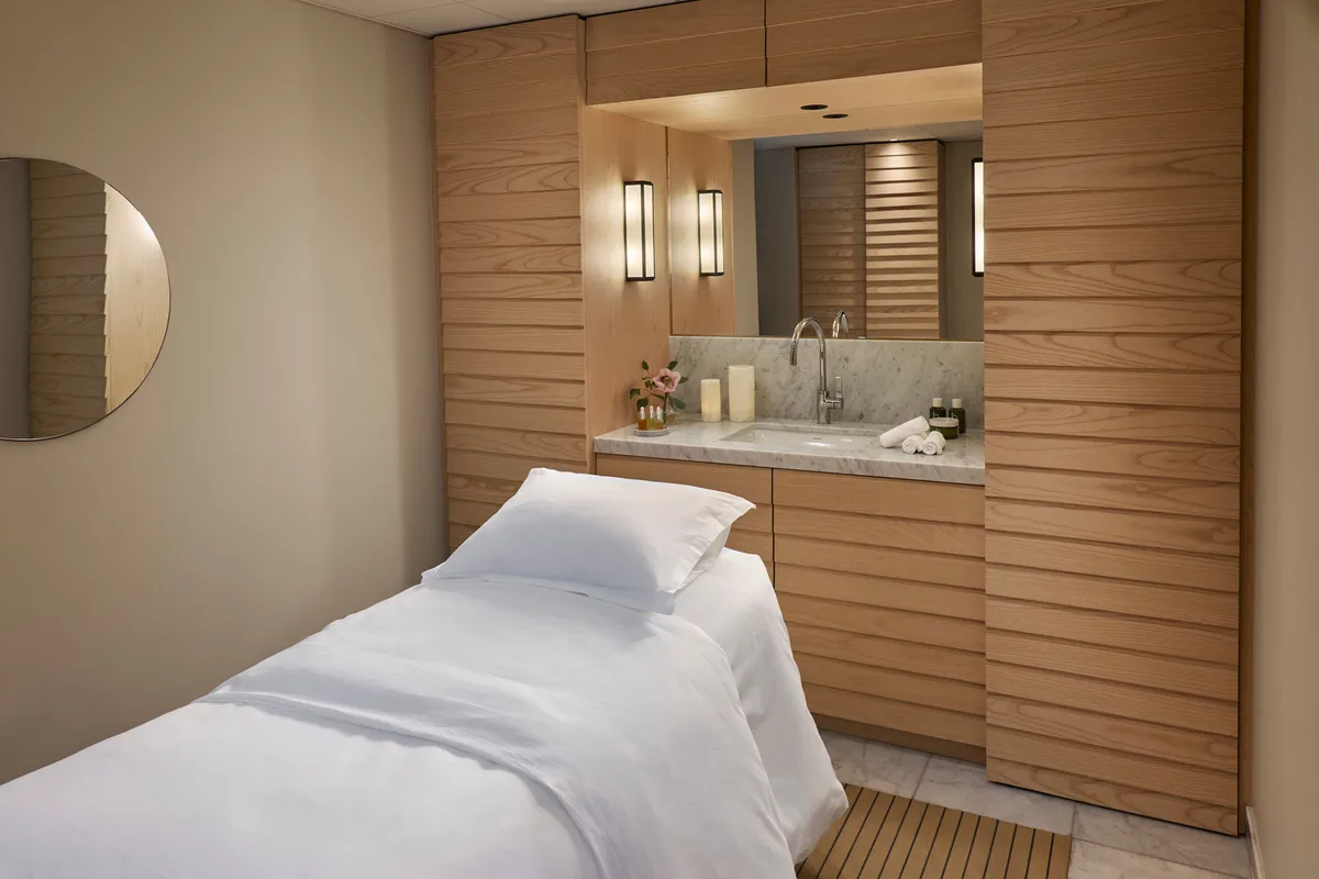 Wellness treatment room with wooden accents and spa massage bed