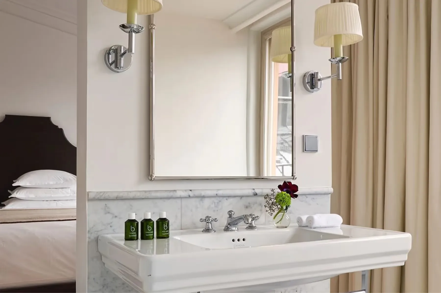 Marble bathroom sink with mirror, brass fixtures, and spa-quality amenities