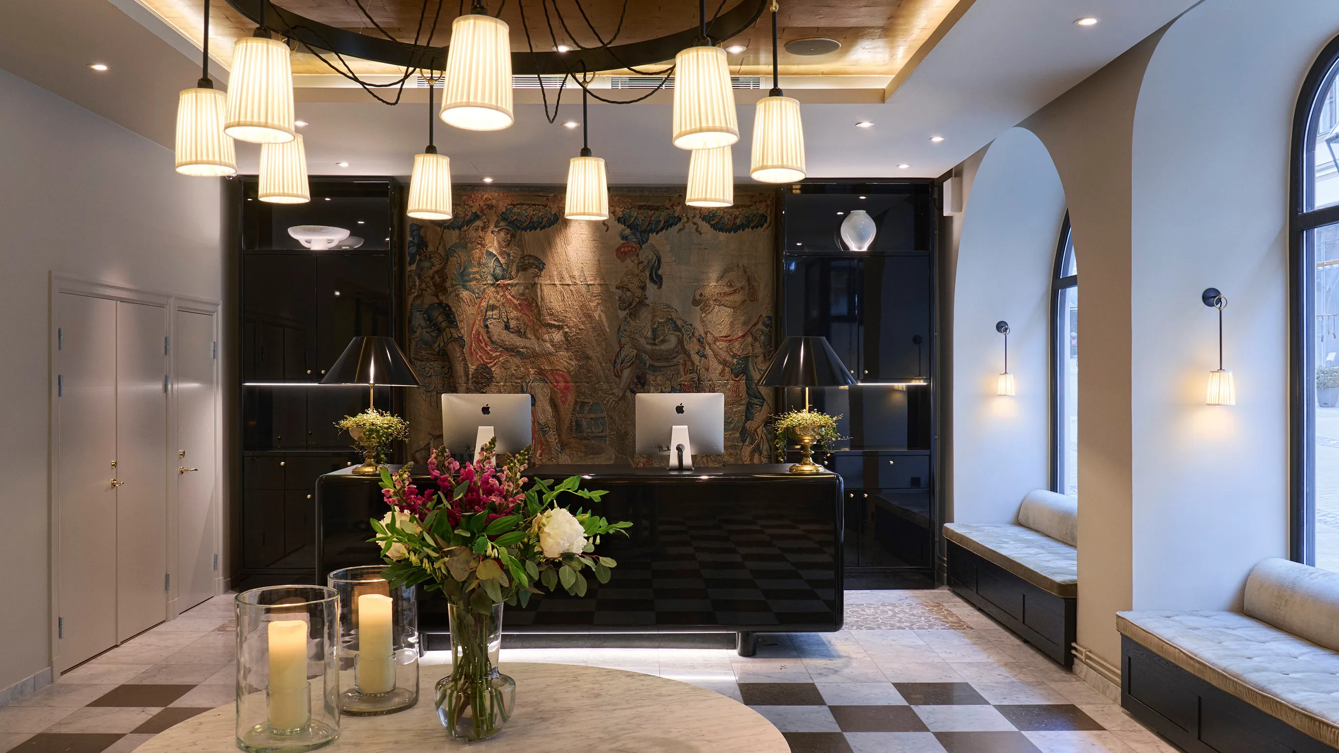 The hotel lobby with dark stone walls, brass accents, and hanging pendant lights