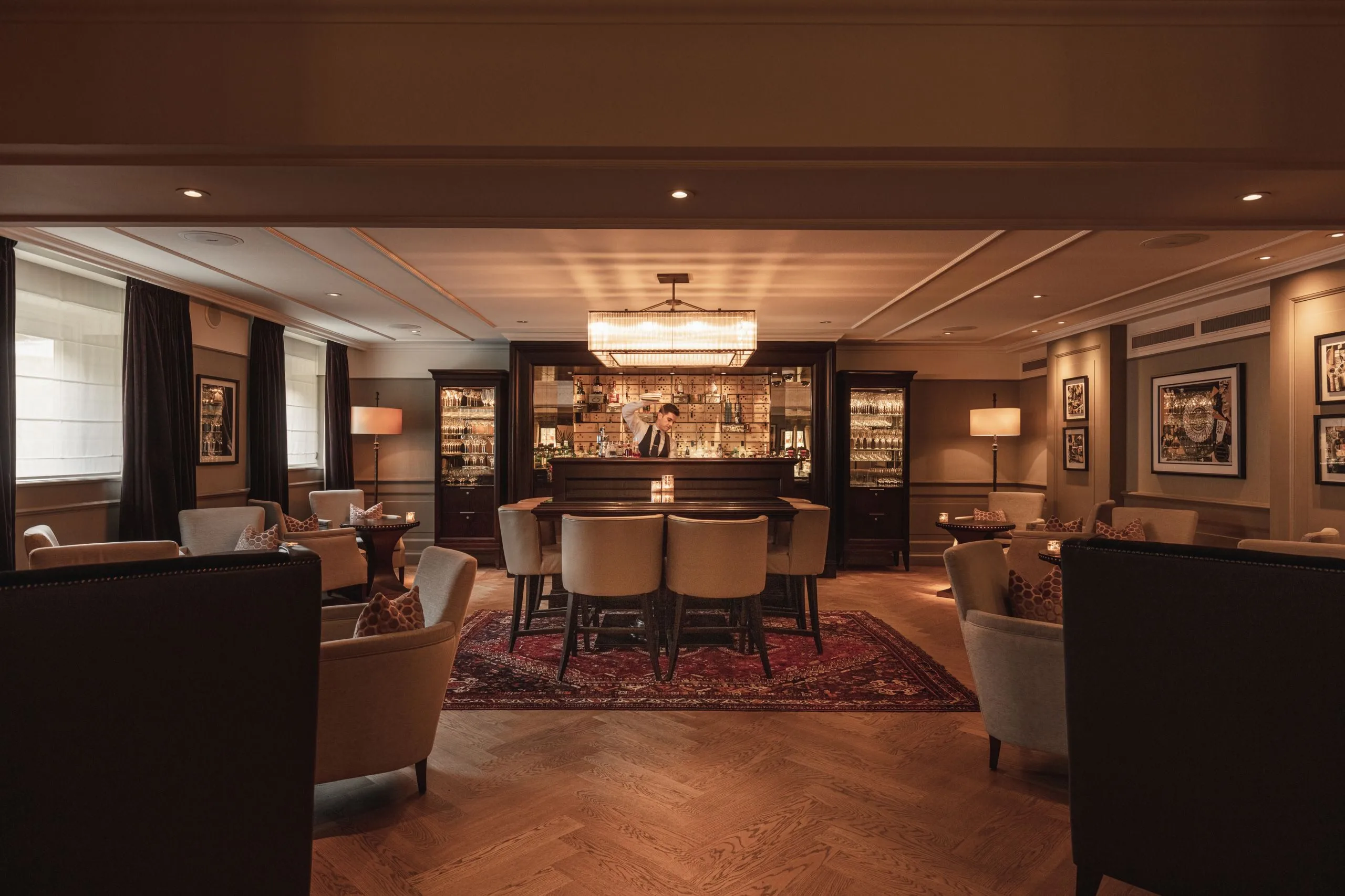 A lobby with dark wood finishes, illuminated display cabinets, and a warm-toned orientation counter